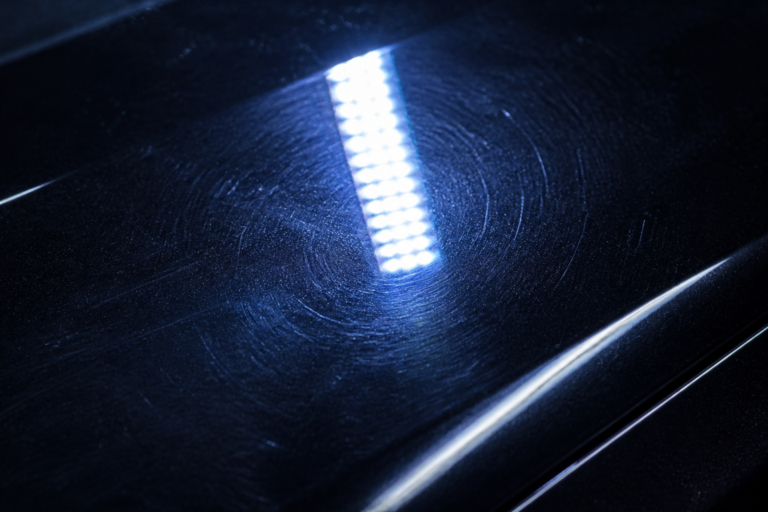 Mikrokratzer und Swirls im schwarzen Autolack unter LED Licht